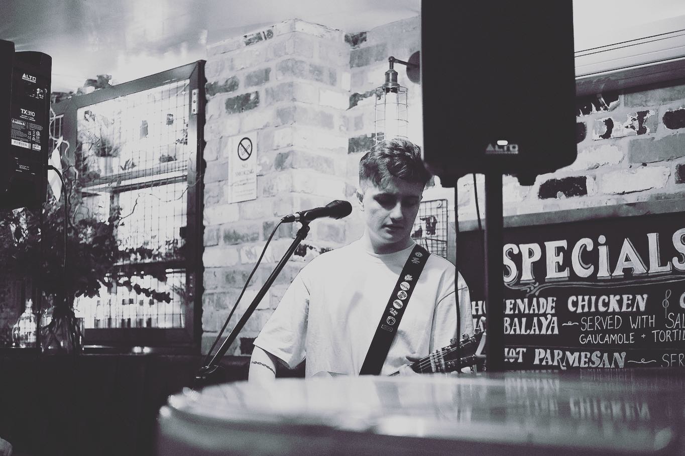 Michael Plumb playing acoustic guitar at a venue