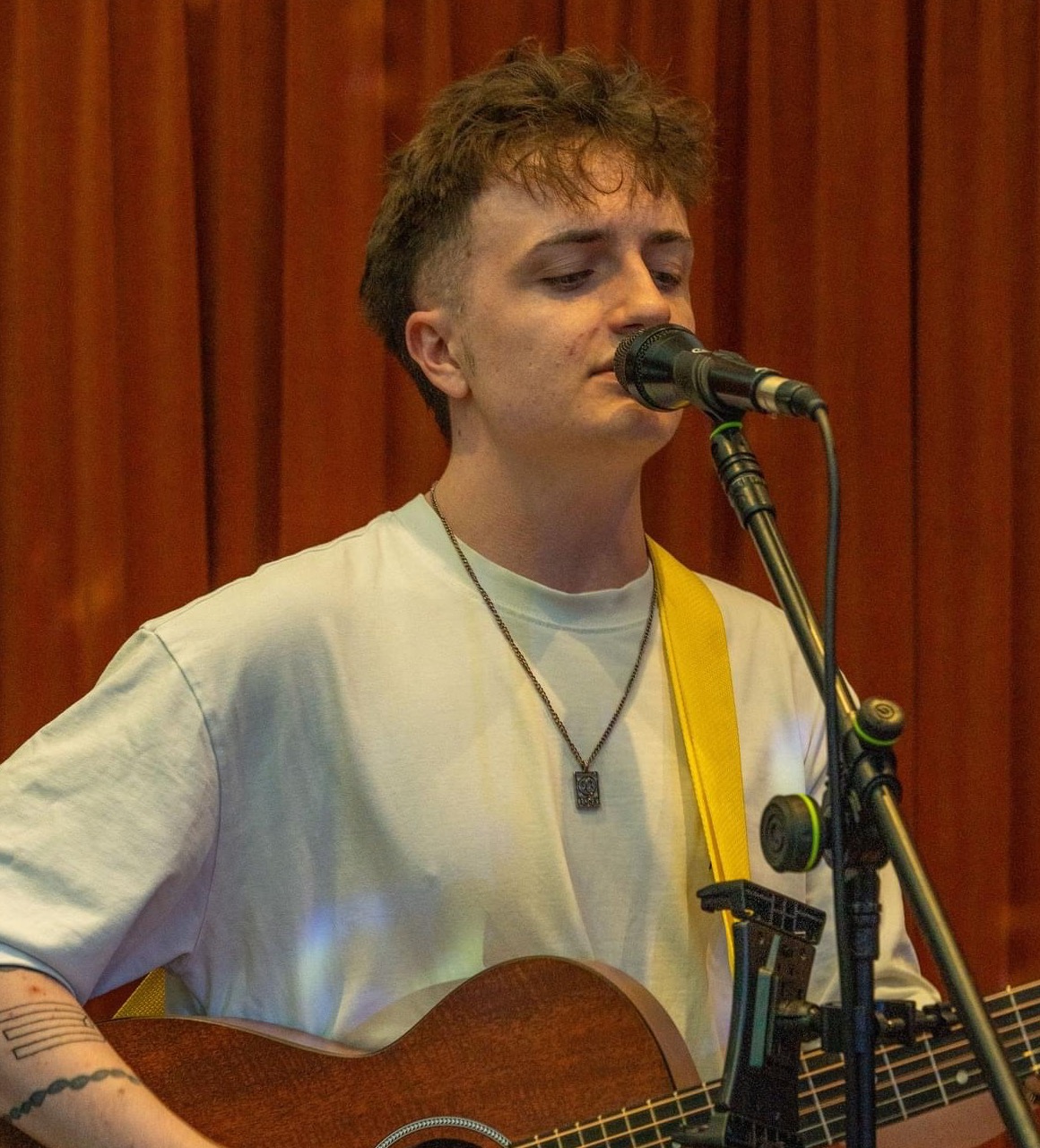 Michael Plumb singing and playing acoustic guitar